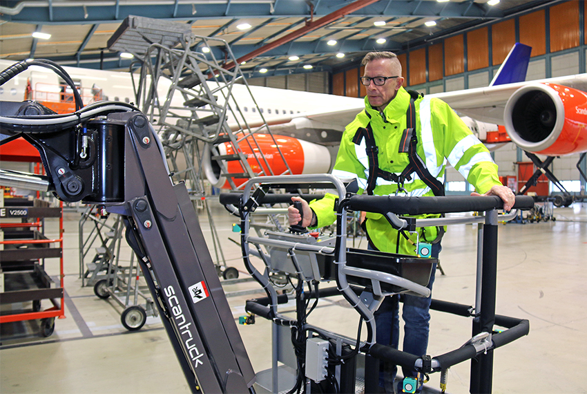 Miljø- og sikkerhedsleder Michael Skriver manøvrerer nemt og enkelt rundt med Manitou-liften i hangaren i Københavns Lufthavn. De små, lyseblå bokse med en rund cirkel er anti-kollisions systemets sensorer, som sidder på alle hjørner af liften.